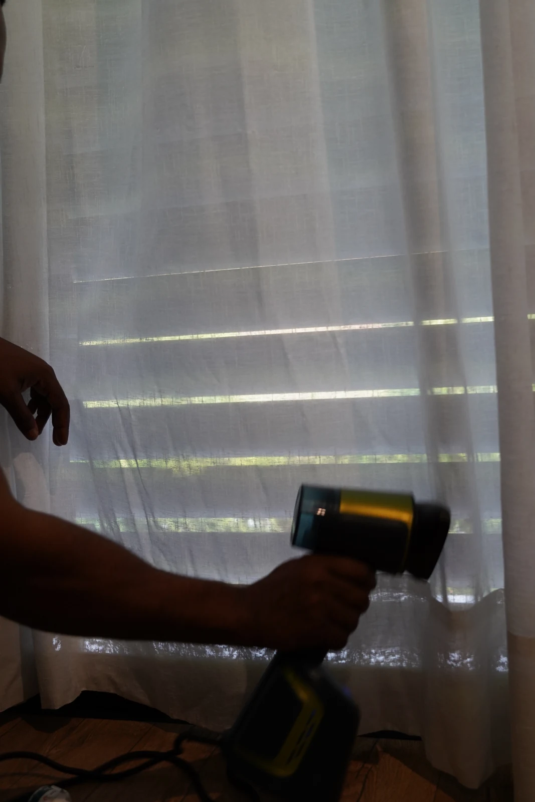 Mãos a aplicar vapor num cortinado